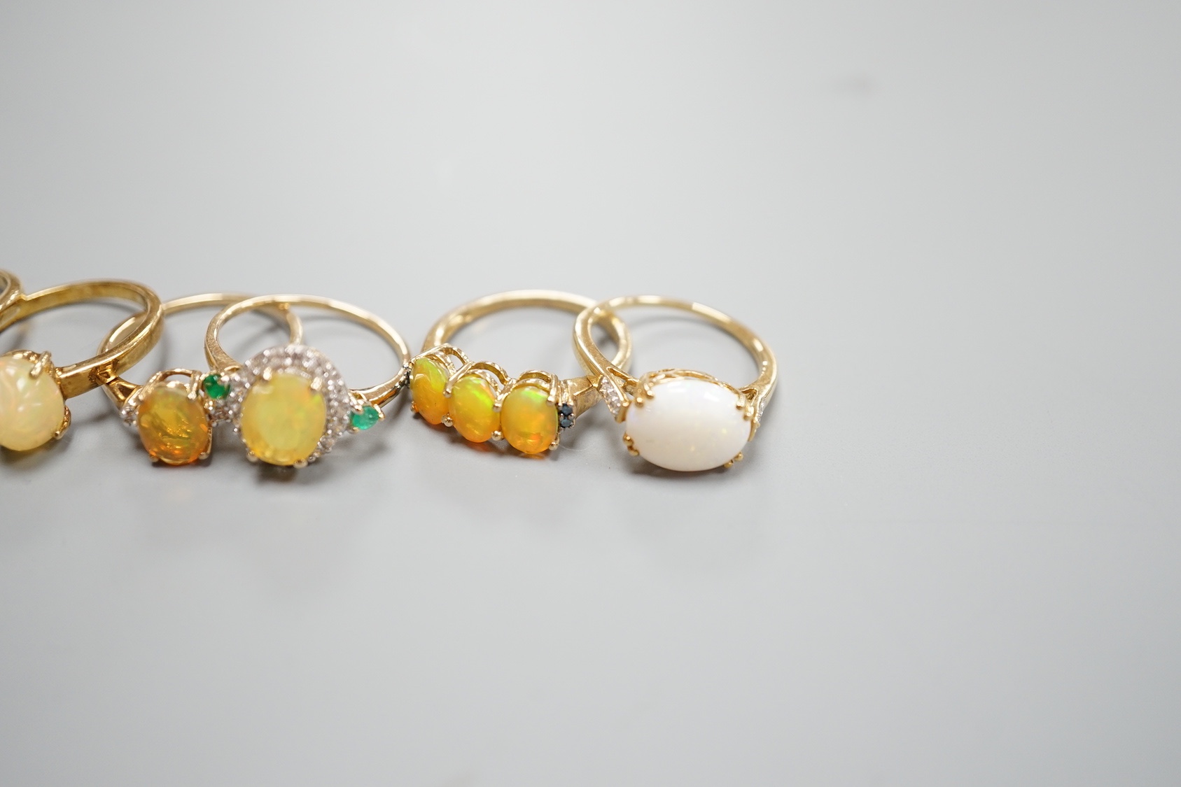 Seven assorted modern 9ct gold, opal and gem set dress rings, gross 14.6 grams and a 925 ring.